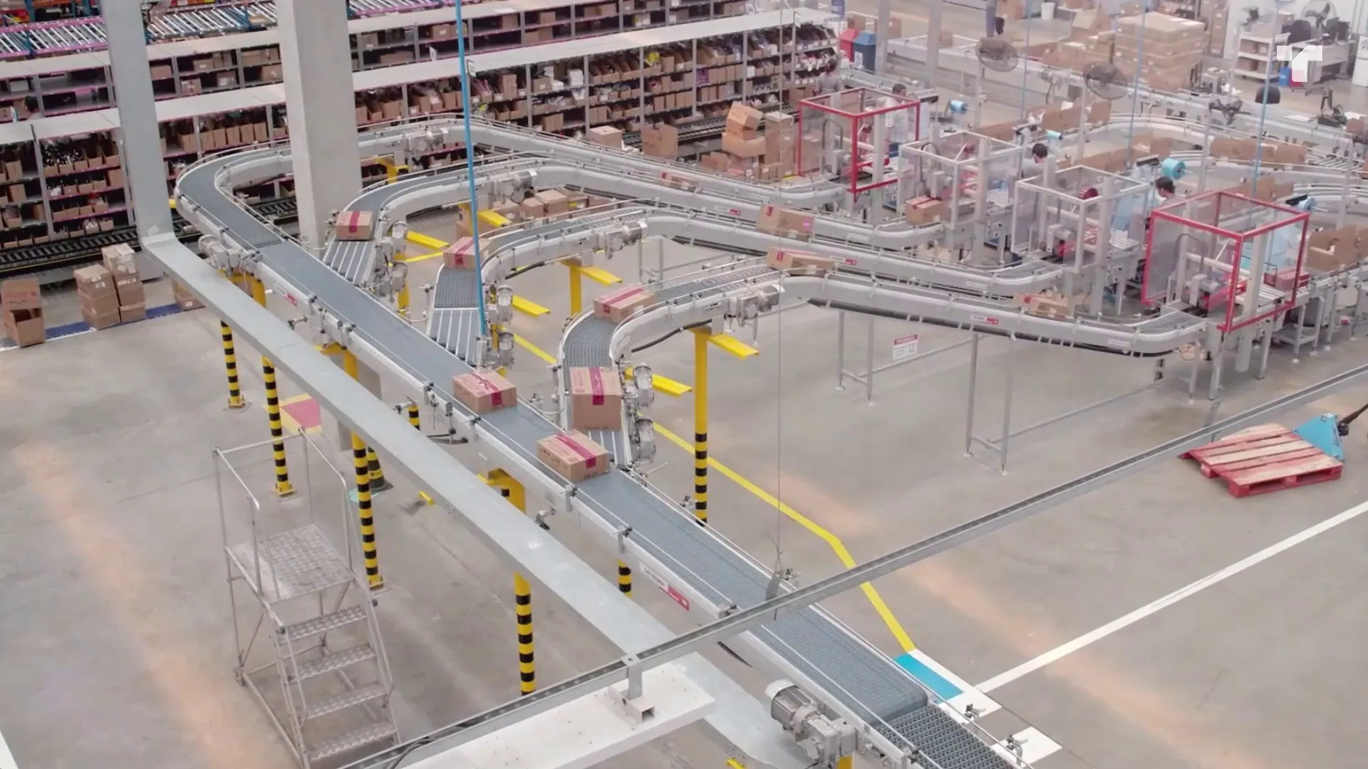 Distribution center palletizing: elevated conveyor lines routing cartons across a distribution center floor.