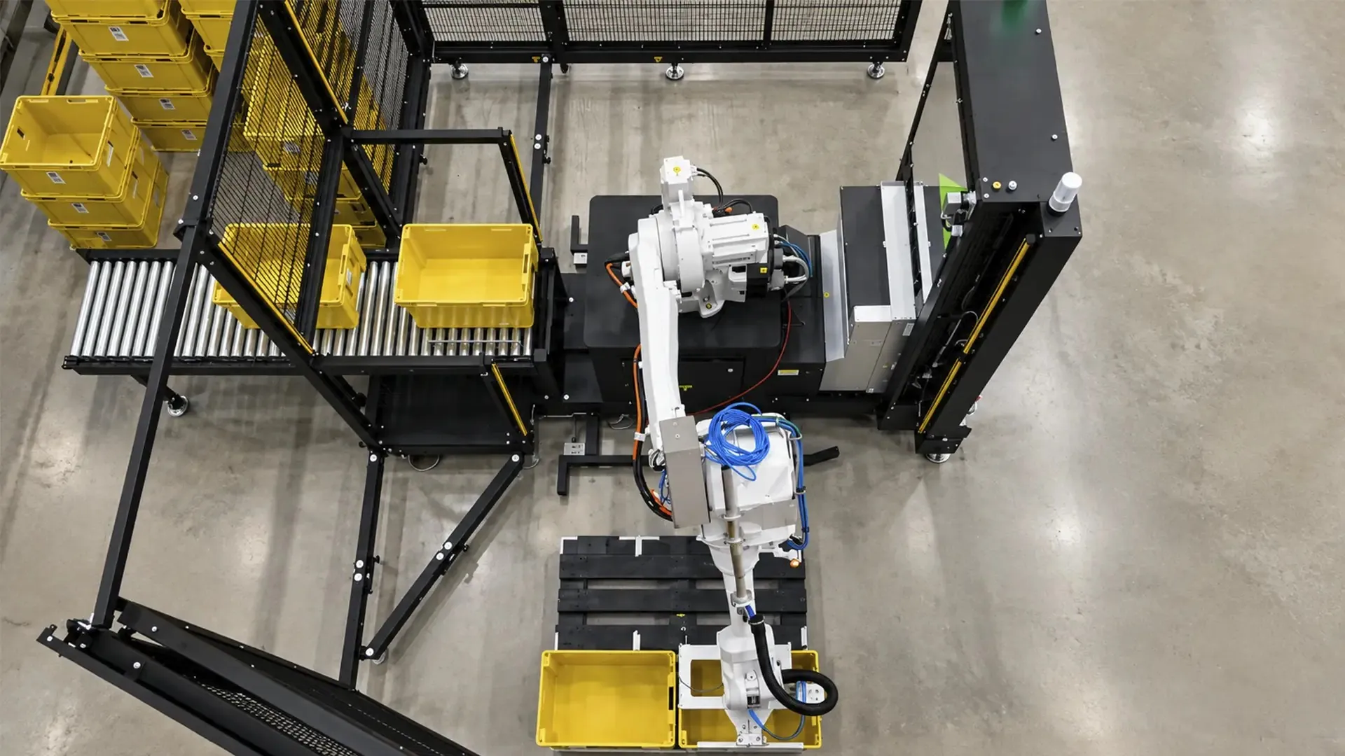 Distribution center palletizing: TRFIntraflow conveyors carrying cartons past shelving in a distribution center.