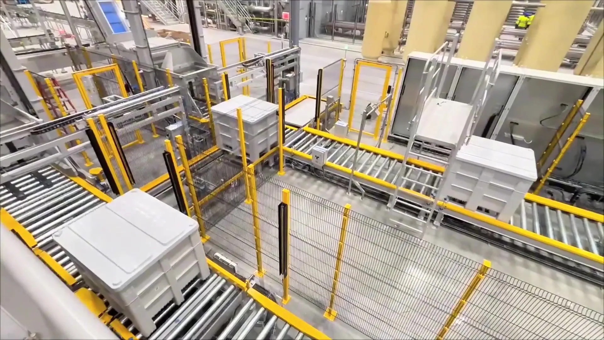 TRF palletizing cell: robot base and control cabinet beside a case conveyor.