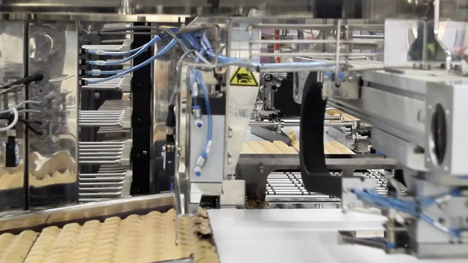 TRFCleanflow conveyor carrying meat cuts through a trim area.