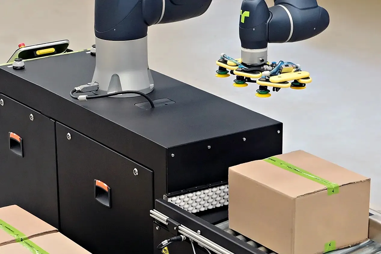 TRFCobot vacuum gripper moving in to pick a case from the infeed conveyor.