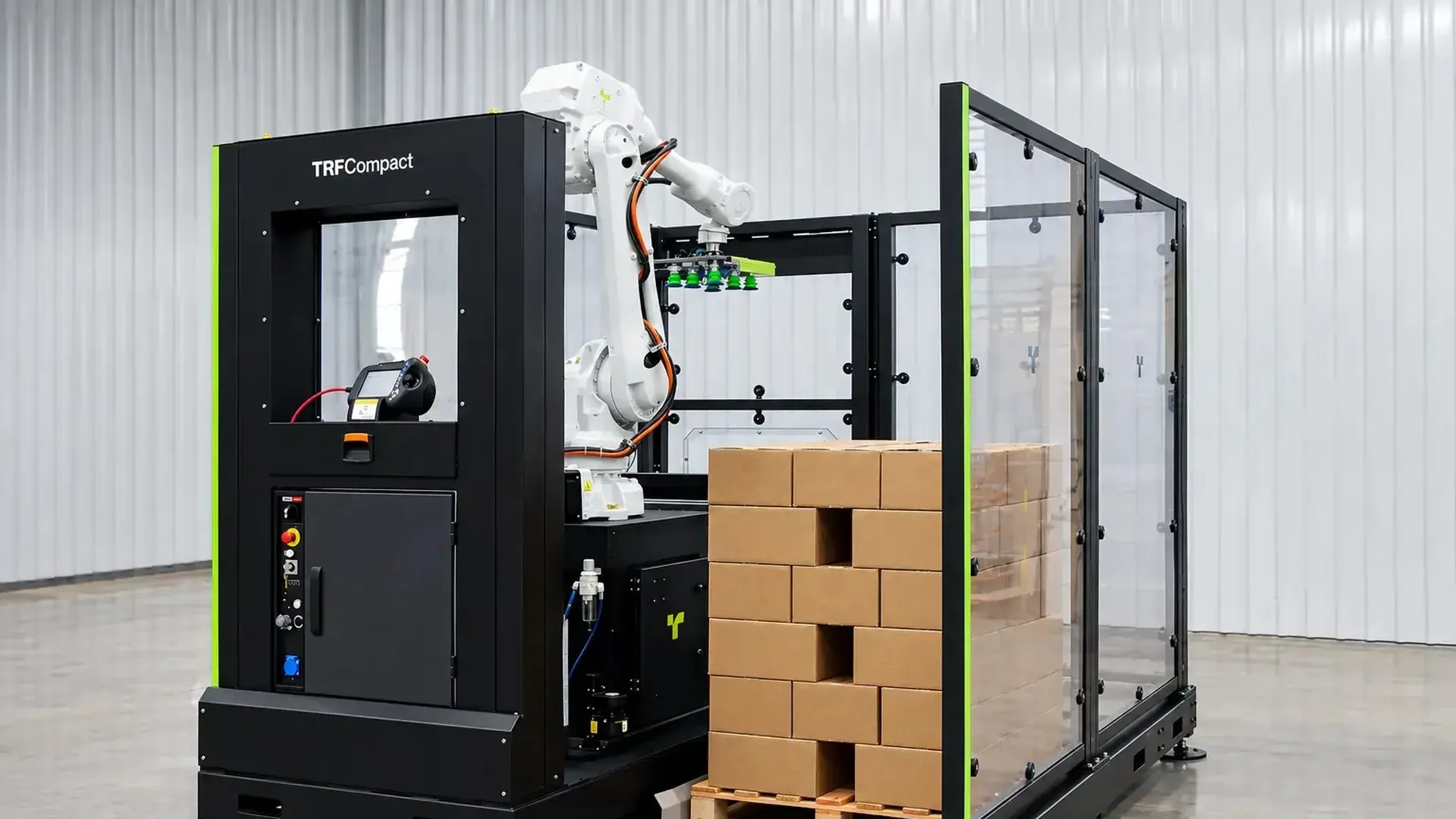 TRFCompact compact palletizer with polycarbonate guarding, an industrial robot and a pallet of stacked cases.