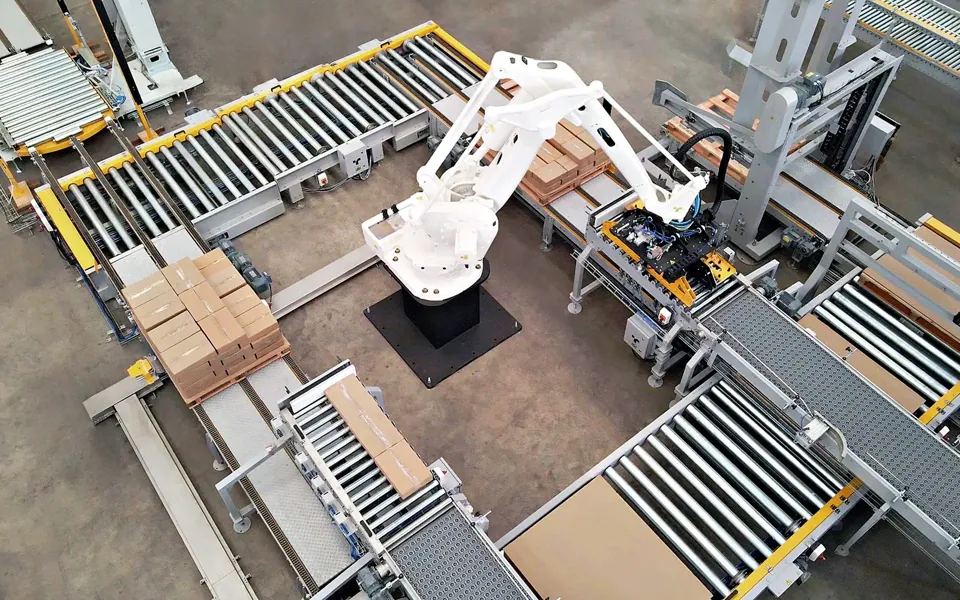 TRFSpeed 300 aerial view: white robot, pallet stations and case conveyors on the plant floor
