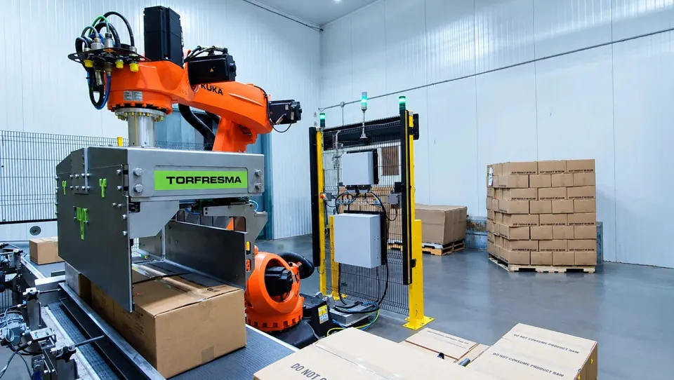 TRFSubzero gripper and KUKA robot handling a case on the infeed conveyor inside a refrigerated room at Custom Foods